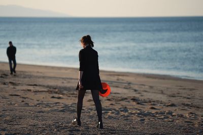 Full length of woman walking on sand at beach