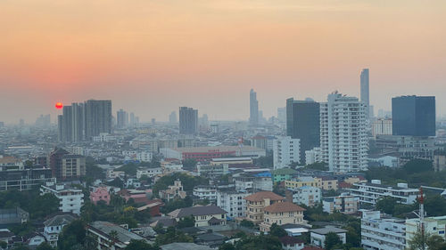 High angle view of buildings in city against sky during sunset