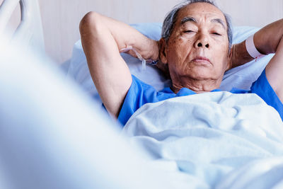 Senior man lying on bed in hospital