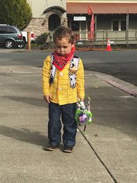 Full length of boy standing on street in city