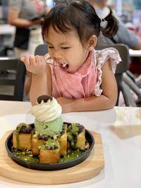 Girl having food at table in restaurant