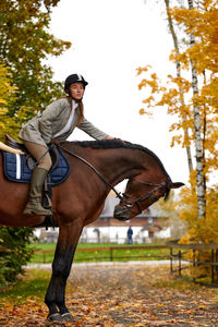 Portrait of young woman riding horse in park