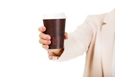 Midsection of man holding drink against white background