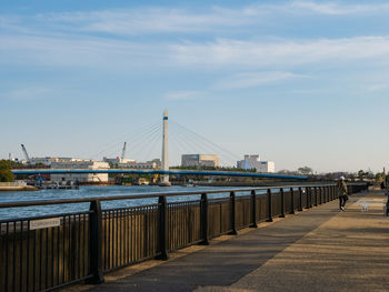 Bridge over river in city against sky