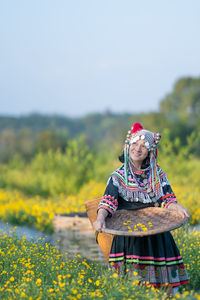 Woman with umbrella standing on field