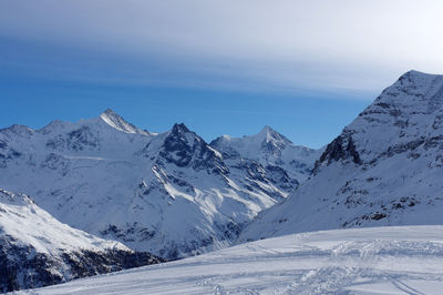 Scenic view of snow covered mountains against sky