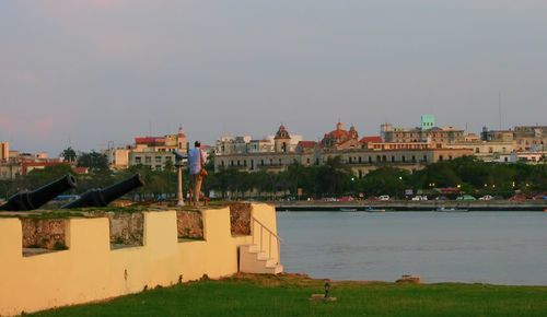 Buildings at waterfront against sky