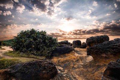 Rocks on land against sky during sunset