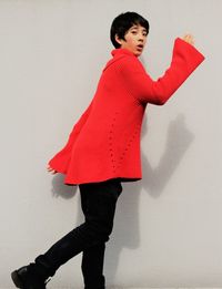 Young woman standing against wall