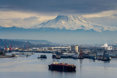 Scenic view of sea and snowcapped mountains against sky