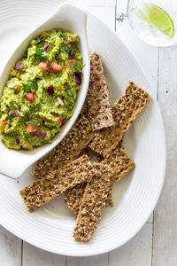 Rustic multi grain cracker sticks served with homemade guacamole.