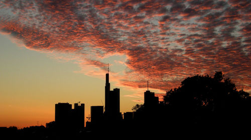 Silhouette cityscape against sky during sunset