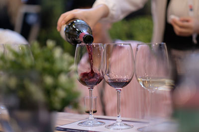 Close-up of hand holding wine glass on table