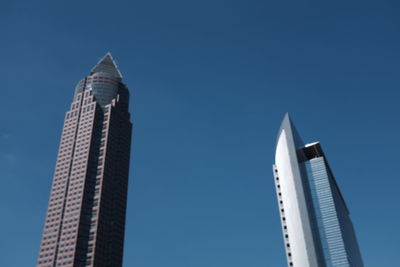 Low angle view of messeturm against blue sky