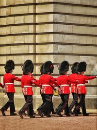 Group of people standing against red brick wall