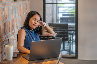 Businesswoman using laptop at cafe