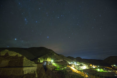 High angle view of illuminated cityscape against sky at night