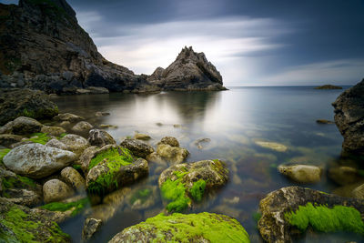 Scenic view of rock formation in water against sky