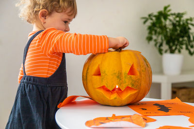 Portrait of boy with jack o lantern on pumpkin