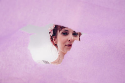 Portrait of woman against pink wall