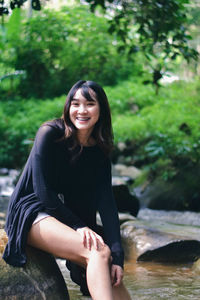 Portrait of young woman sitting at park