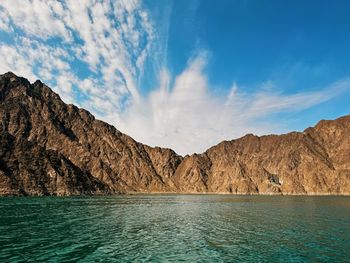 Scenic view of sea and mountains against sky