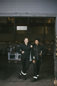 Professional female colleagues standing on doorway of warehouse