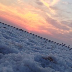 Scenic view of snow against sky during sunset