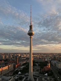 A rooftop view of berlin tv tower and the cityscape during the sunset with colorful clouds.