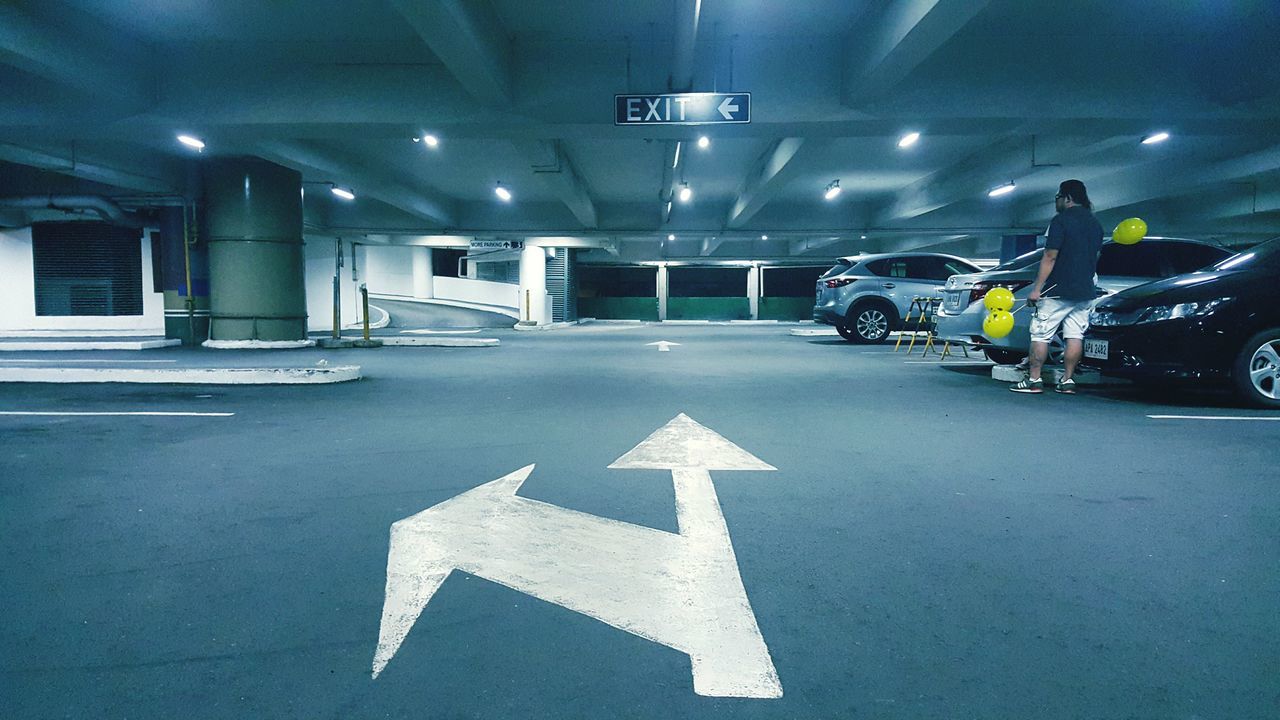 illuminated, road marking, transportation, night, the way forward, guidance, text, arrow symbol, road, communication, street, western script, diminishing perspective, built structure, lighting equipment, directional sign, sign, architecture, indoors, information sign