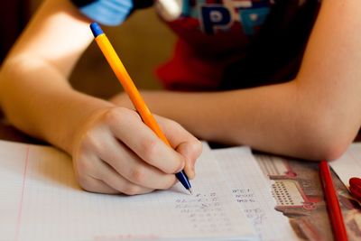 Cropped image of boy doing homework