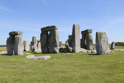 View of stonehenge with green meadow and blue sky on a sunny day in spring, united kingdom