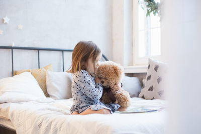 Rear view of woman relaxing on bed at home