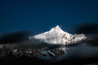 Scenic view of snowcapped mountains against clear blue sky