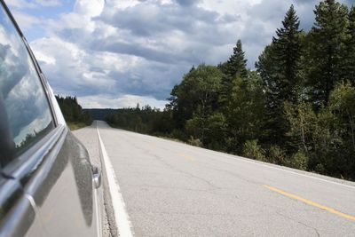 Road amidst trees against sky