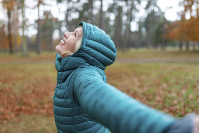 Side view of young woman looking away on field during winter