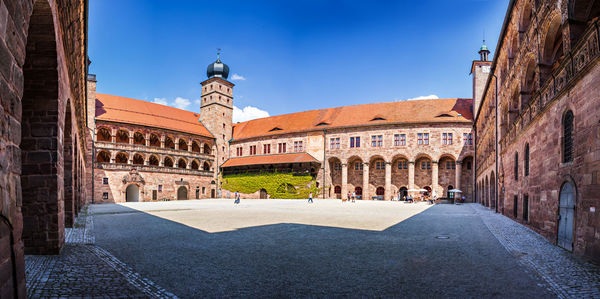 Buildings in city against clear blue sky