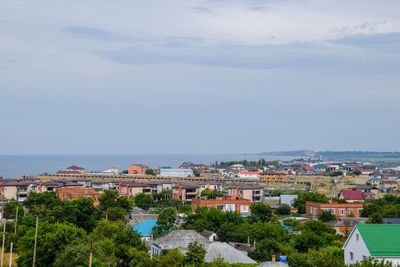 High angle view of townscape by sea against sky