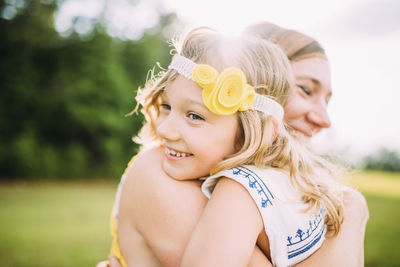 Happy mother and daughter embracing at park