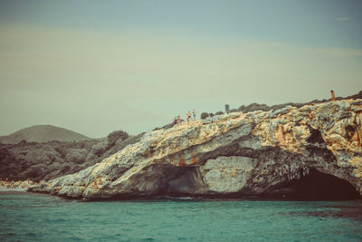 Rock formations by sea against sky