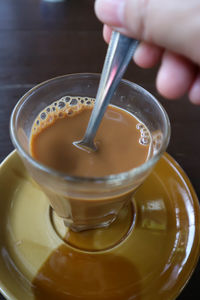 Close-up of hand pouring drink in glass