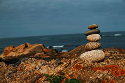 Stack of rocks on shore against sky