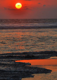Scenic view of sea against orange sky