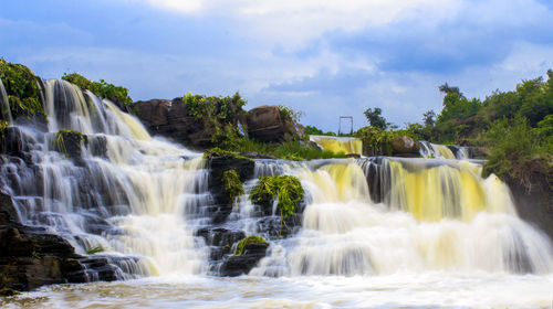 Low angle view of waterfall against sky