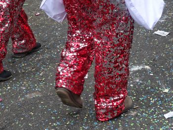 Low section of man with red umbrella