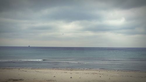 Scenic view of sea against cloudy sky