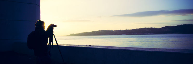 Woman standing by sea against sky