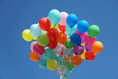 Low angle view of balloons against blue sky