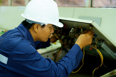 Side view of engineer working in workshop