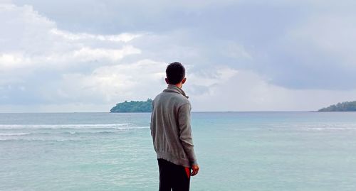 Rear view of man standing on beach